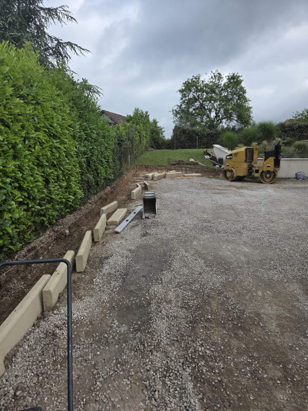 Travaux d'aménagement d'une cour avec la pose de bordures ciment type P1 beige