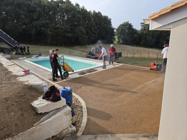 Mise en œuvre autour d'une piscine d'enrobé drainant beige réalisé par l'entreprise TCTP