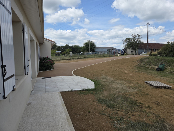 Réalisation d'un enrobé beige 0/10 et de béton désactivé autour d'une maison par l'entreprise TCTP
