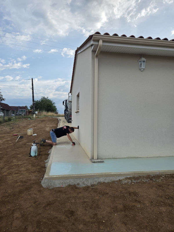 Lissage du béton autour d'une maison avant passage du désactivant réalisé par l'entreprise TCTP