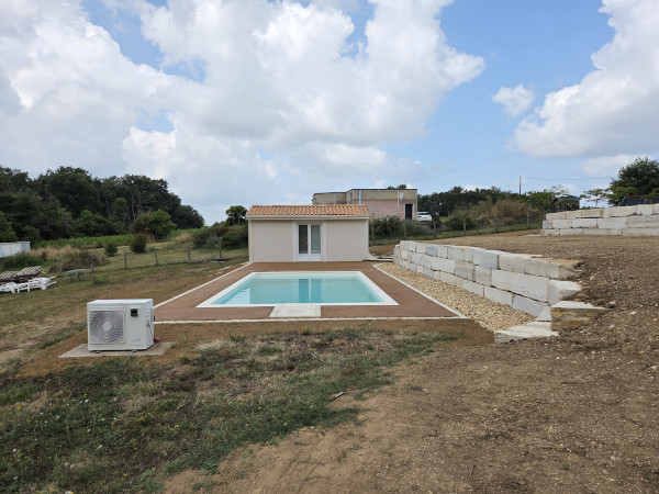 Mise en œuvre autour d'une piscine d'enrobé drainant beige réalisé par l'entreprise TCTP