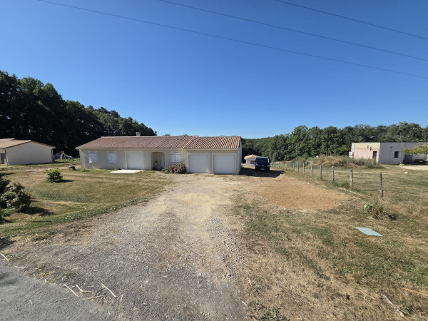 Réalisation d'enrobés beige d'enrochement et de béton désactivé pour aménager les espaces autour de cette maison située en Dordogne