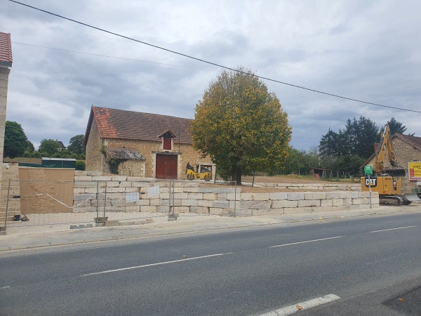 Mise en œuvre avec une pelleteuse Caterpillar 315d e blocs d'enrochement de Limeyrat provenant de la carrière de Montagnac d'auberoche pour l'aménagement des espaces autour du bureau de tabac à Fossemagne par l'entreprise SARL TCTP en Dordogne