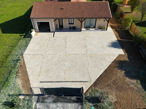 Photo prise après la réalisation de l'aménagement d'une maison individuelle par l'entreprise Sarl TCTP en Dordogne à Azerat en collaboration avec l'entreprise construction Yohan Chazotte en béton désactivé beige petit galet et la pose de pavés en pierre de Montagnac d'auberoche