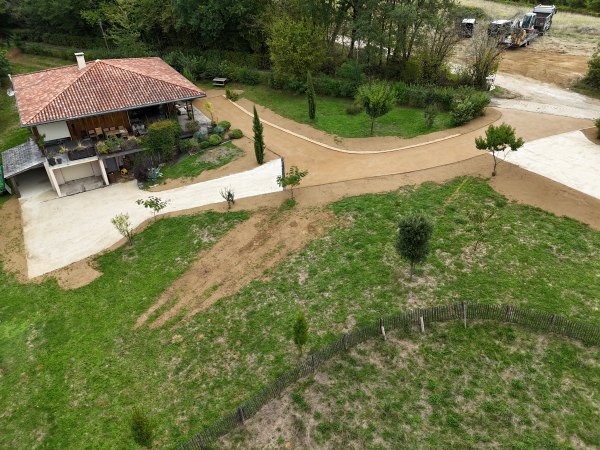 Cour et allées d'une maison à Rouffignac en enrobé beige et en calcaire 0/20 de campagne avec des caniveaux à grille fonte réalisé par l 'entreprise SARL TCTP en Dordogne