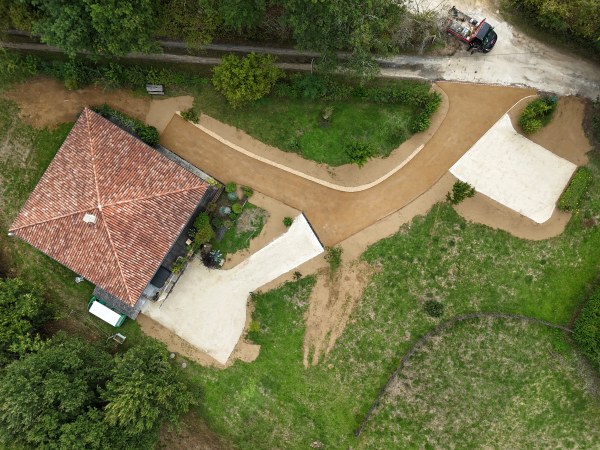 Revêtement cour et allées d'une maison à Rouffignac en enrobé beige et en calcaire 0/20 de campagne avec des caniveaux à grille fonte réalisé par l 'entreprise SARL TCTP en Dordogne