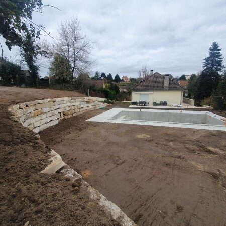 Réalisation par l'entreprise SARL TCTP en Dordogne d'un enrochement pour le soutènement et l'aménagement des espaces verts autour d'une piscine creusée en blocs de Limeyrat pierre du Périgord