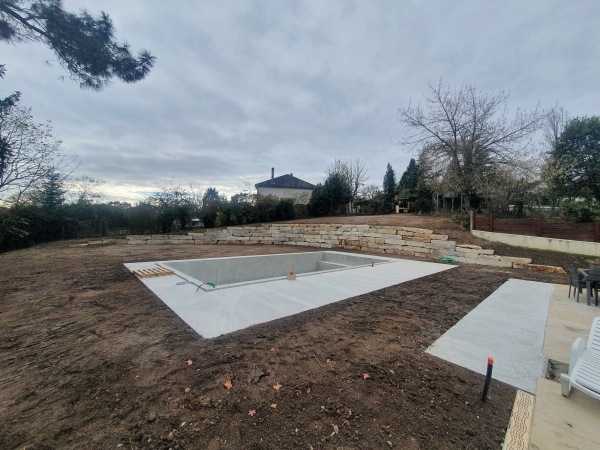 Réalisation par l'entreprise SARL TCTP en Dordogne d'un enrochement pour le soutènement autour d'une piscine creusée en blocs de Limeyrat pierre du Périgord